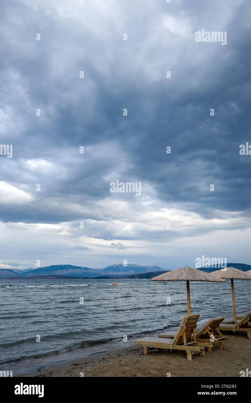 Kalamaki, Corfù, Grecia, lettini e ombrelloni sulla spiaggia di Kalamaki nel nord-est dell'isola greca di Corfù, sullo sfondo la terraferma di Albani Foto Stock
