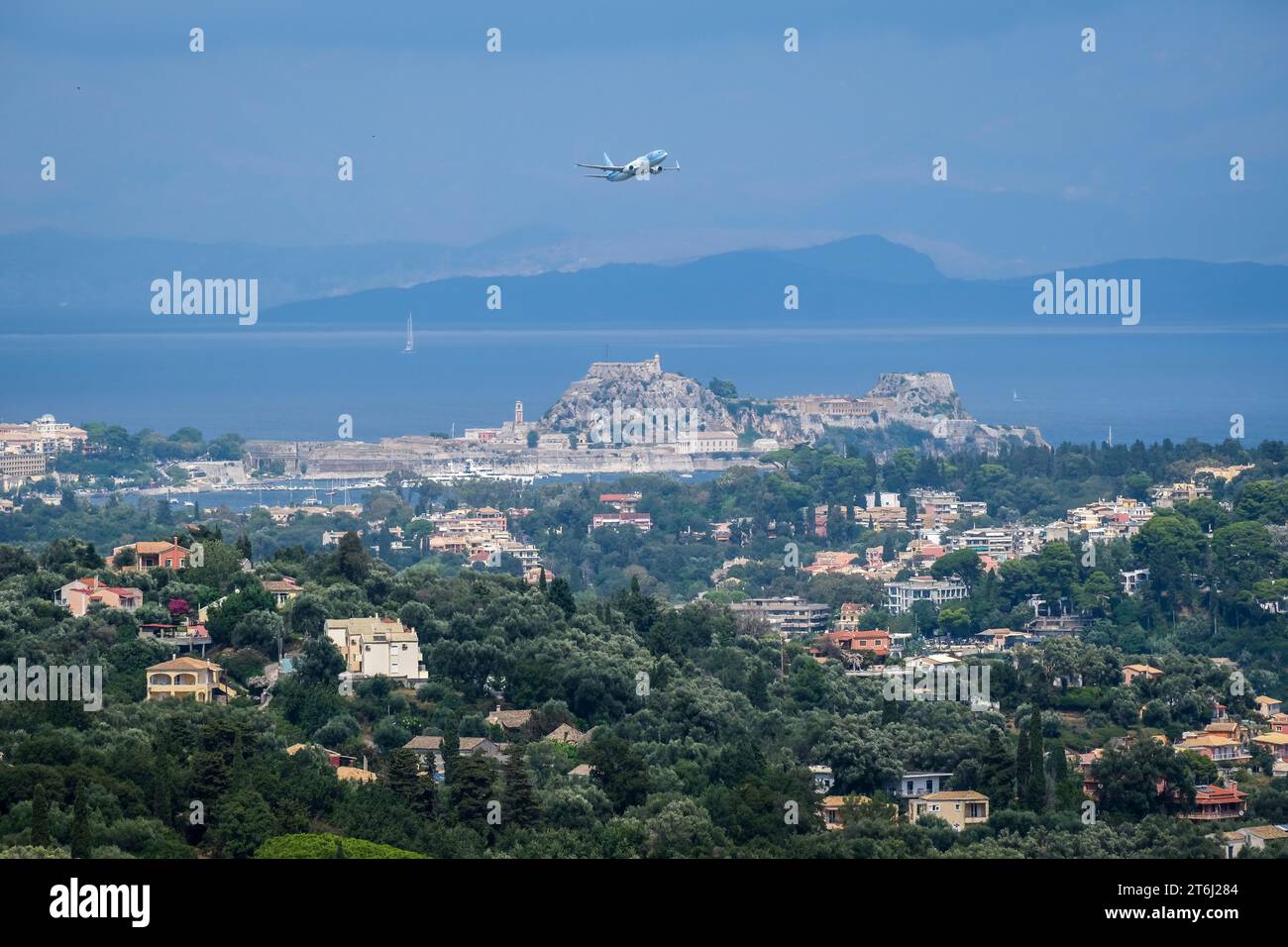 Panoramica della città di Corfù, Corfù, Grecia, città di Corfù. L'aereo TUI decolla dall'aeroporto di Corfù e vola sopra la città, sullo sfondo la terraferma dell'Albania. Foto Stock