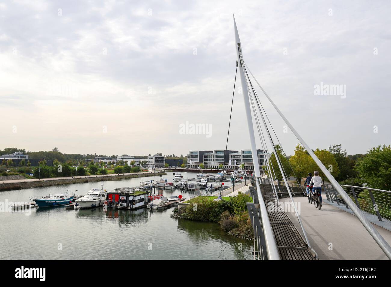 Gelsenkirchen, Renania settentrionale-Vestfalia, Germania, Marina Graf Bismarck (anche Stoelting Marina), marina nel nuovo quartiere della città Graf Bismarck, sito dell'ex miniera Graf Bismarck, sul canale Reno-Herne nel distretto di Gelsenkirchen Bismarck. I ciclisti cavalcano sul ponte del porto di Graf Bismarck. Foto Stock