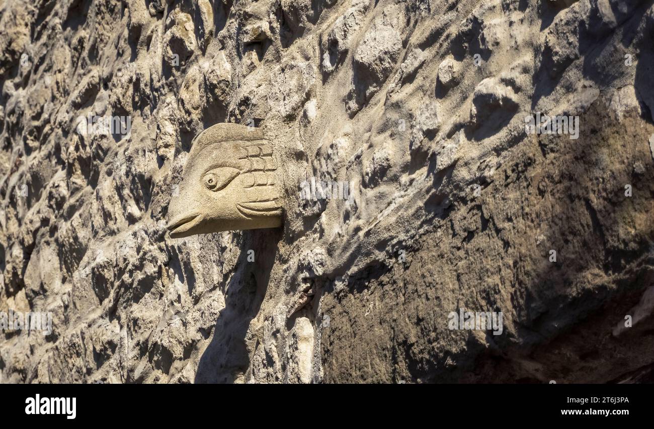 Maschera di pietra sul muro di pietra ad Aigne. Il centro storico ha la forma di una chiocciola ed è stato costruito nell'XI secolo. Foto Stock