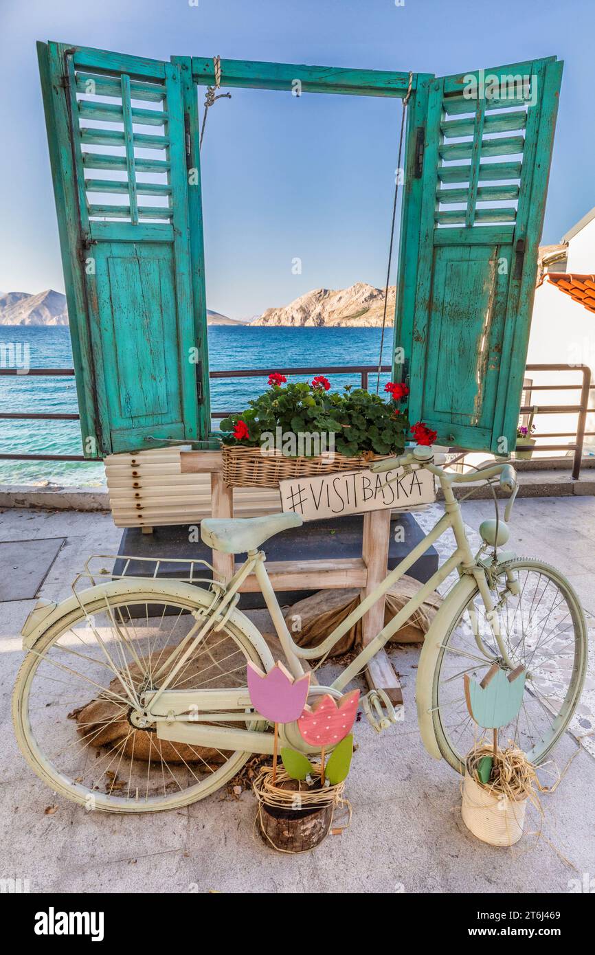Croazia, baia del Quarnero, isola di Krk, installazione per i turisti a Baska, finestra con persiane verdi e bicicletta d'epoca, set per foto sui social network Foto Stock