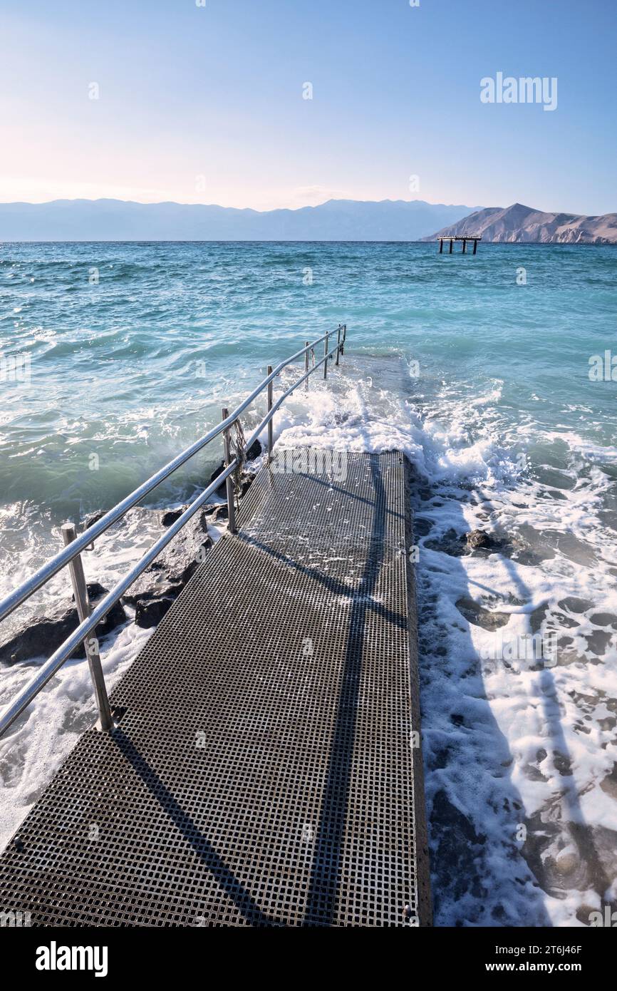 Croazia, baia del Quarnero, isola di Krk, Baska, rampa di accesso al mare (anche per disabili) sulla spiaggia di Baska Foto Stock