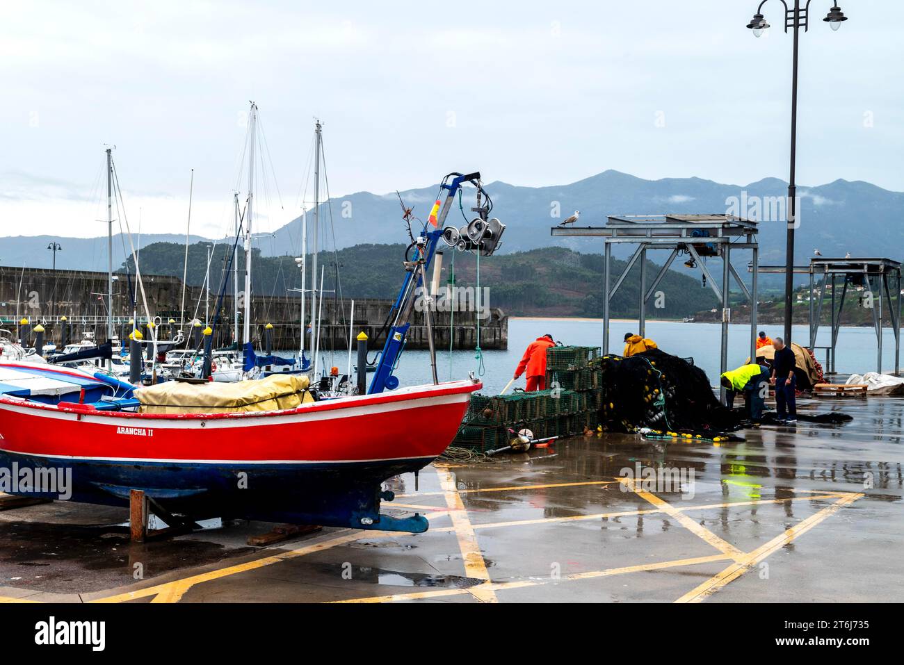 Pescatori che lavorano nel porto di Lastres o Llastres, comune di Colunga, Principado de Asturias, Asturias, Costa Verde, Spagna Foto Stock