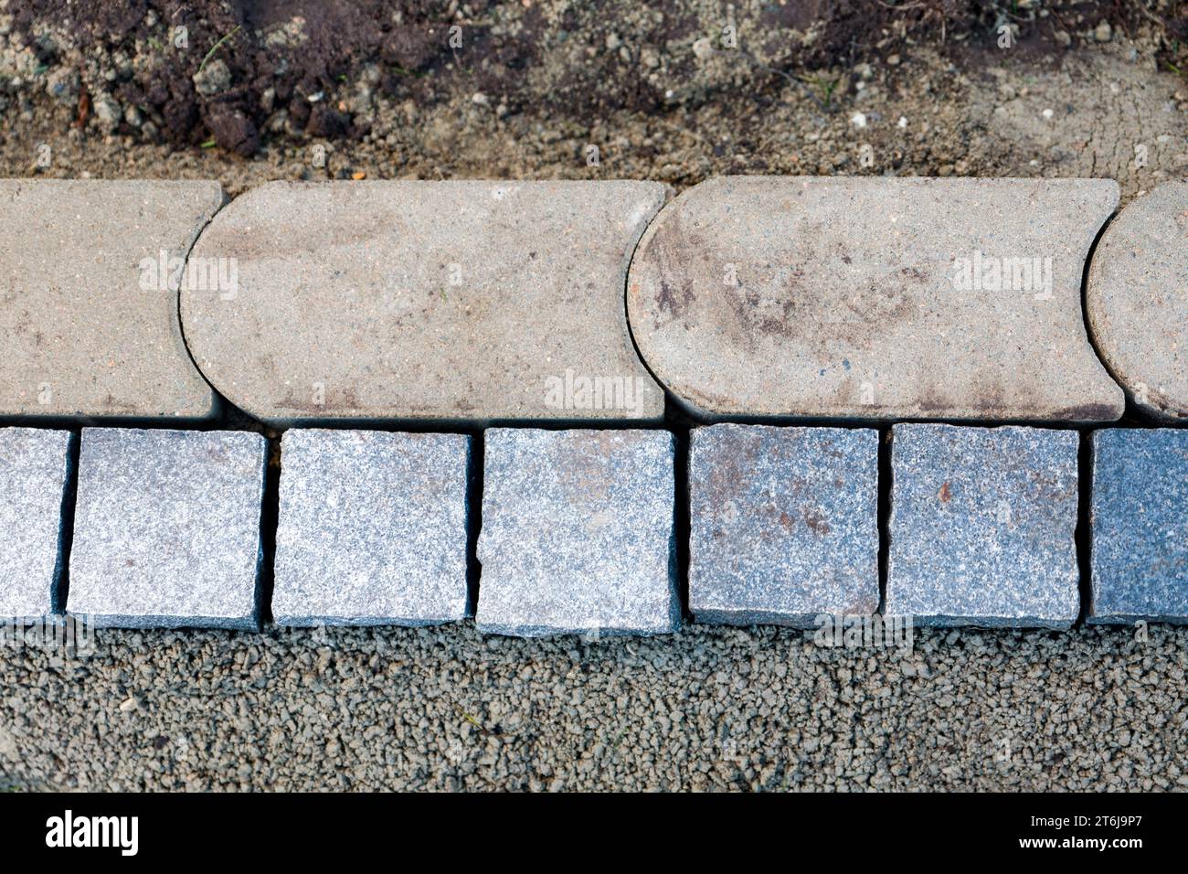 Design da giardino, con la posa di nuove pietre bordanti in un letto di Malta. Foto Stock