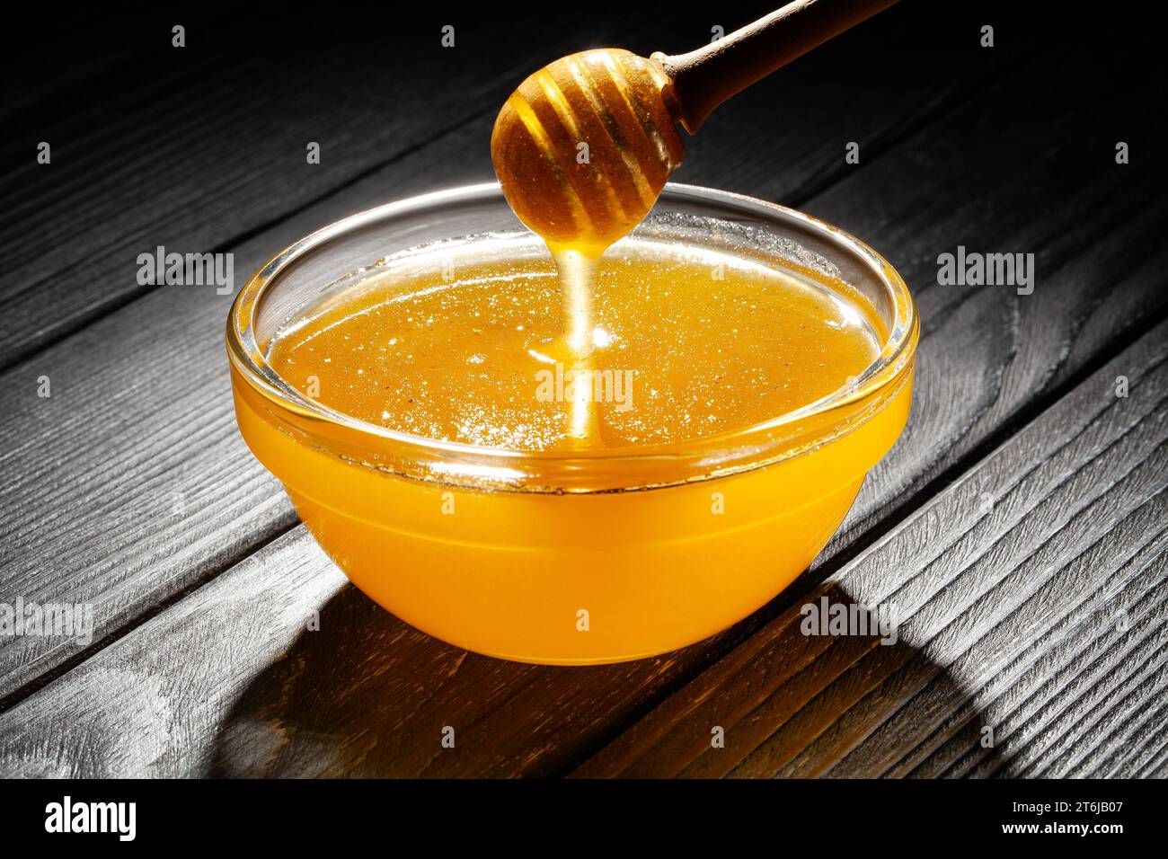 ciotola di miele su fondo di legno Foto Stock