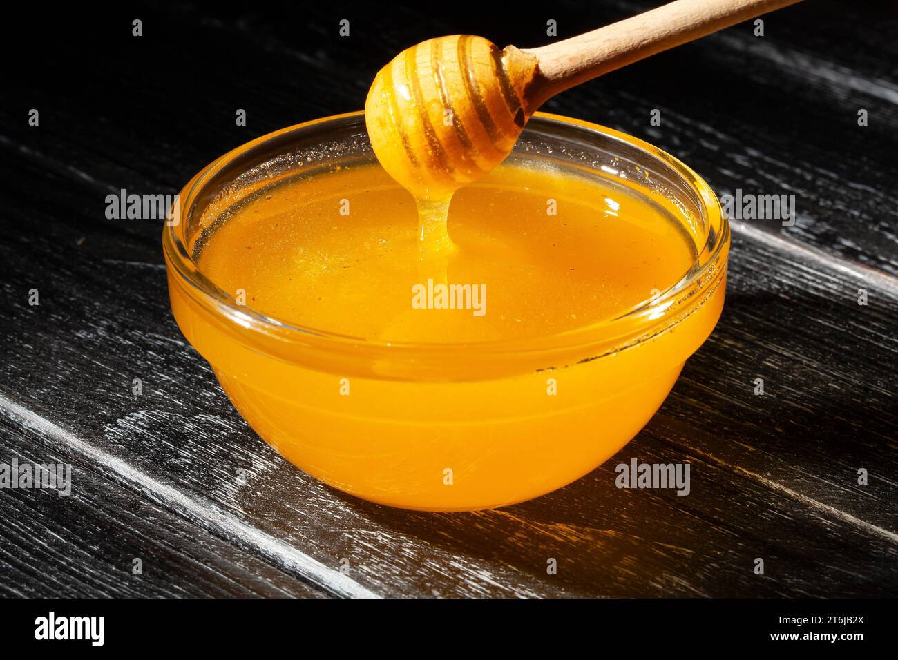 ciotola di miele su fondo di legno Foto Stock