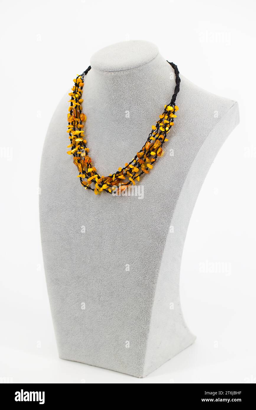 Una collana ambrata elegantemente impreziosita da un cordoncino nero. Le sfumature dorate dell'ambra baltica creano un'estetica calda e naturale. Foto Stock