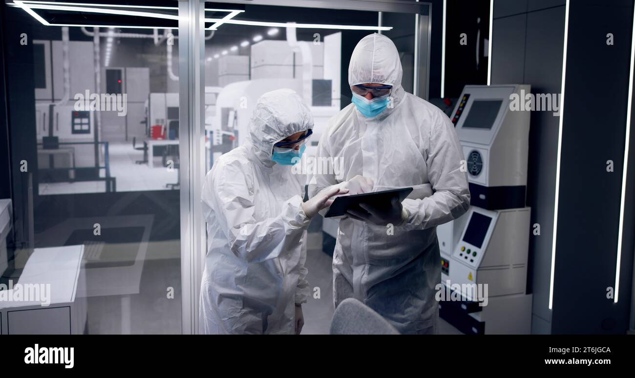 Fabbrica di produzione di semiconduttori sterile e lavoratori in tute Foto Stock