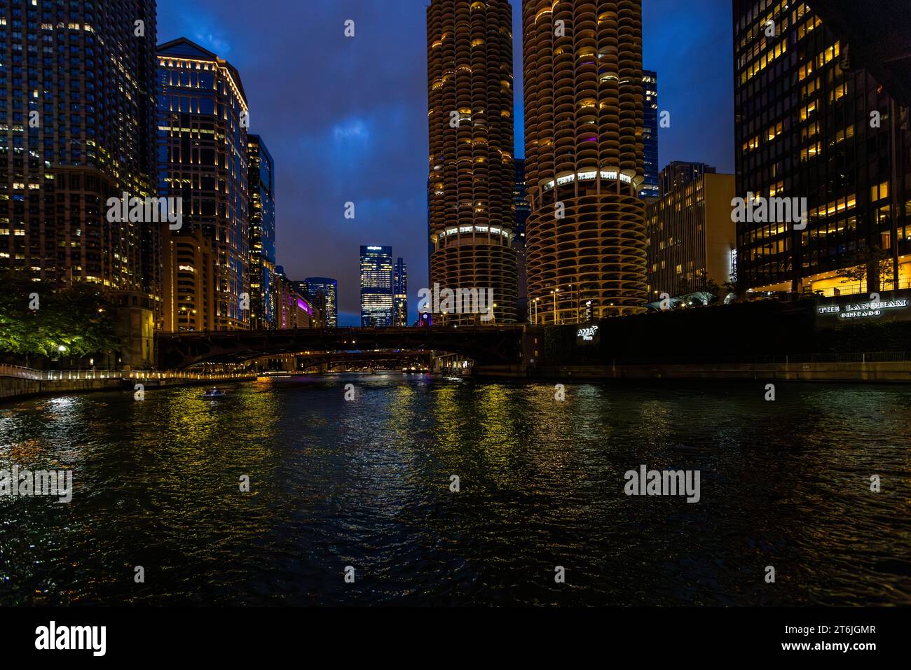 Cammina lungo il lungofiume di Chicago di notte. Vista di Marina City, due grattacieli rotondi del 1964, noti anche come corncobs. Marina Tower di notte. Due torri gemelle alte 179,2 metri sono tra gli edifici più famosi di Chicago. Sono chiamati "pannocchie di mais" a causa del loro aspetto esterno. I 19 piani inferiori hanno spazio per 896 auto. Chicago, Illinois, Stati Uniti Foto Stock