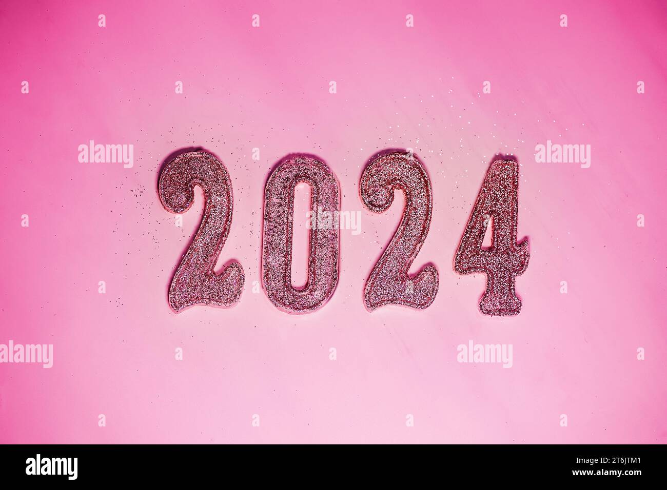 Capodanno 2024. Numeri del prossimo anno su sfondo rosa. Il colore alla moda dell'anno uscente nello stile di una bambola alla moda Foto Stock