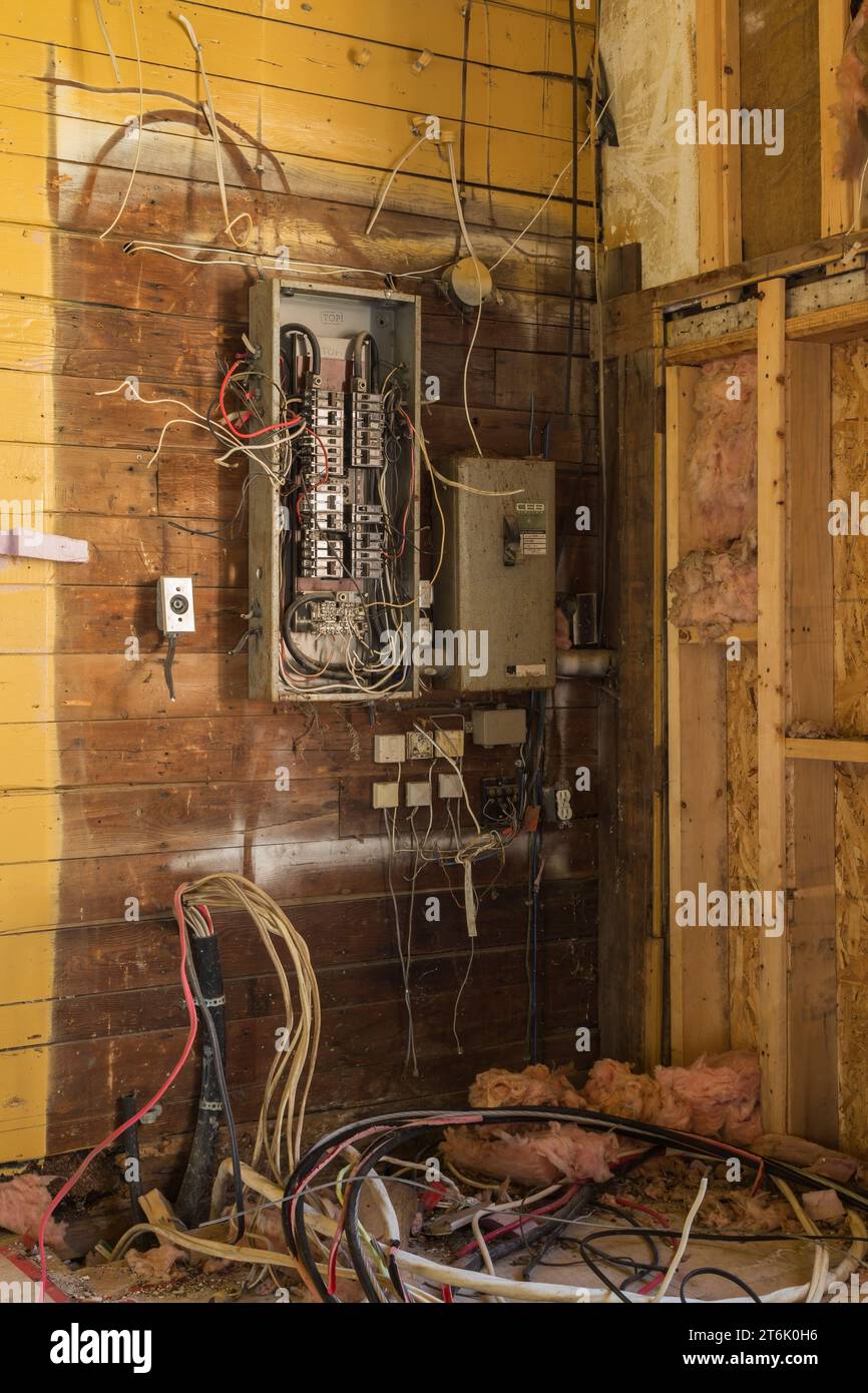 Vecchi pannelli e cavi per la distribuzione dell'elettricità nell'edificio commerciale abbandonato. Foto Stock