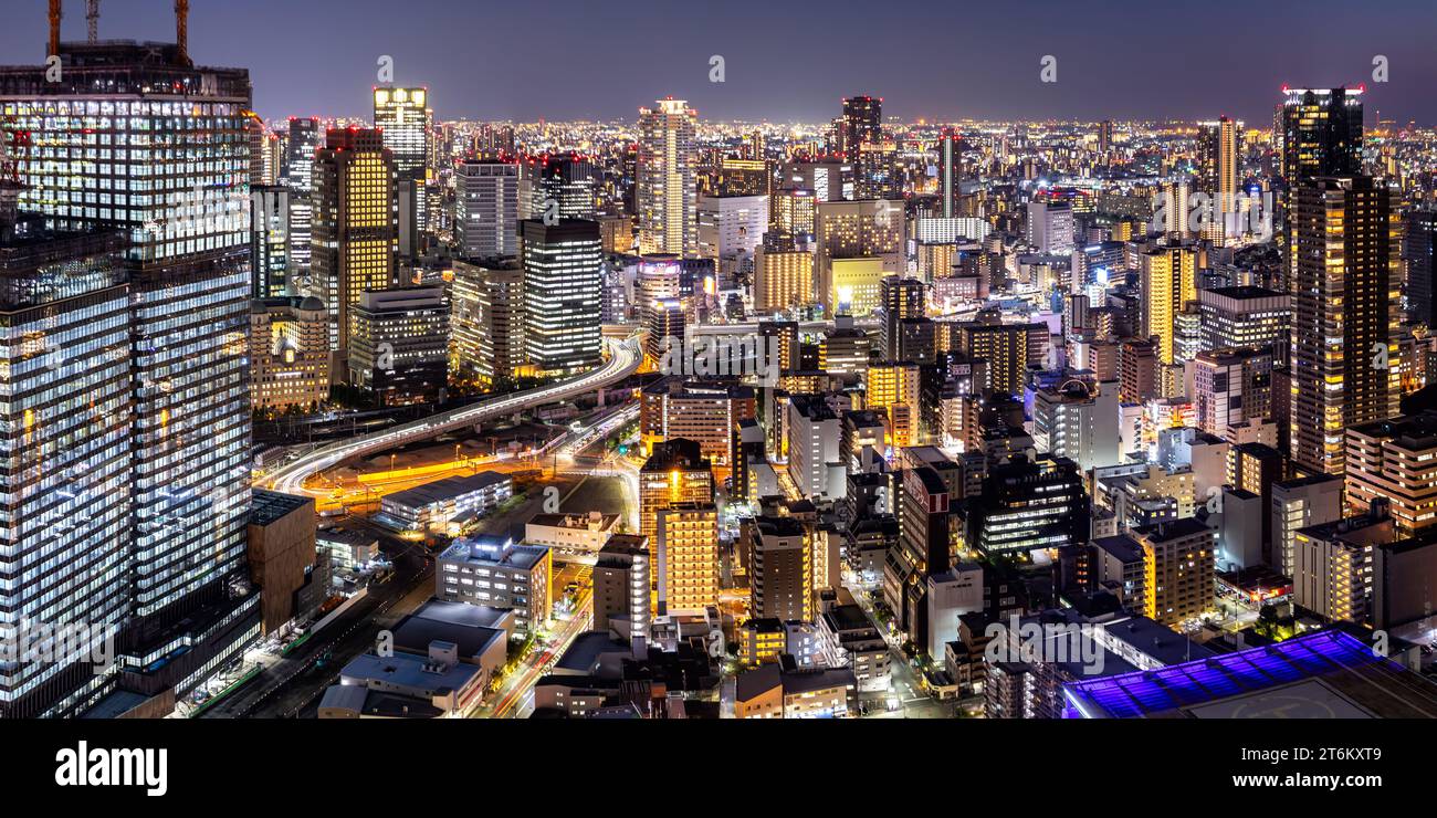 La grande città di Osaka si illumina dall'alto dello skyline con i grattacieli che si affacciano sulla città al crepuscolo in Giappone Foto Stock