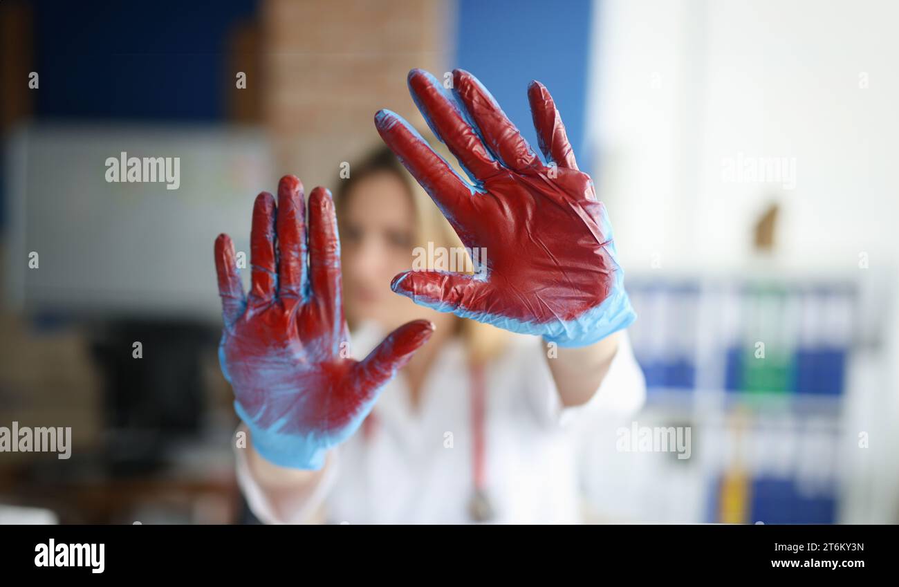 Mano sanguinata in guanti medici medico in clinica Foto Stock