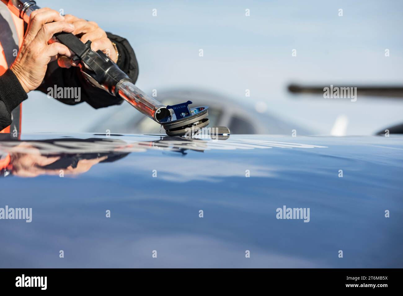 Rifornire l'aereo. L'FBO rifornisce l'aeromobile aziendale prima della partenza. Primo piano di una mano con una pistola per carri armati. Concetto per voli aziendali. Foto Stock Rifornire l'aereo. L'FBO rifornisce l'aeromobile aziendale prima della partenza. Primo piano di una mano con una pistola per carri armati. Concetto per voli aziendali. Foto Stock