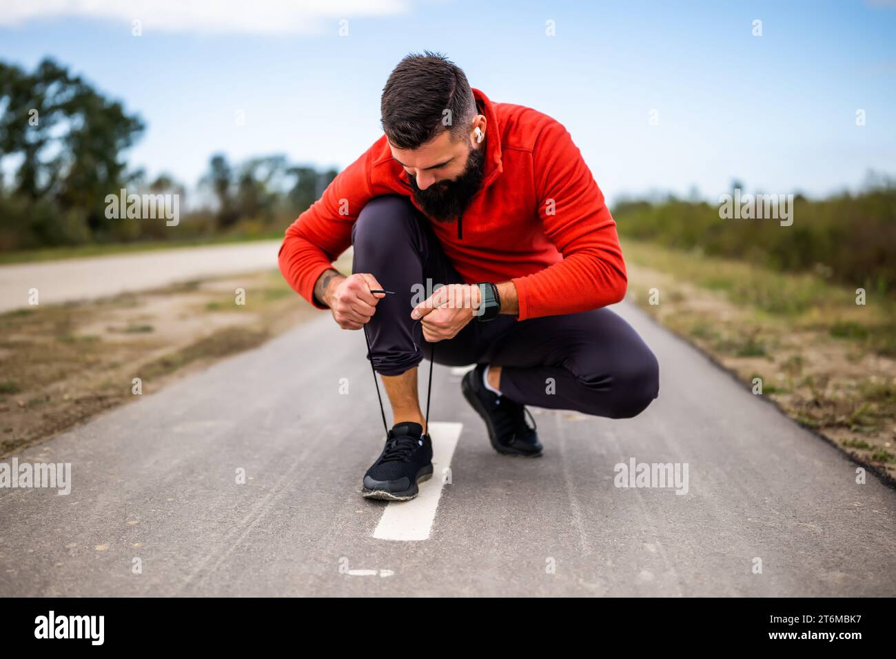 l'uomo oung sta legando un lacci prima di fare jogging. Foto Stock