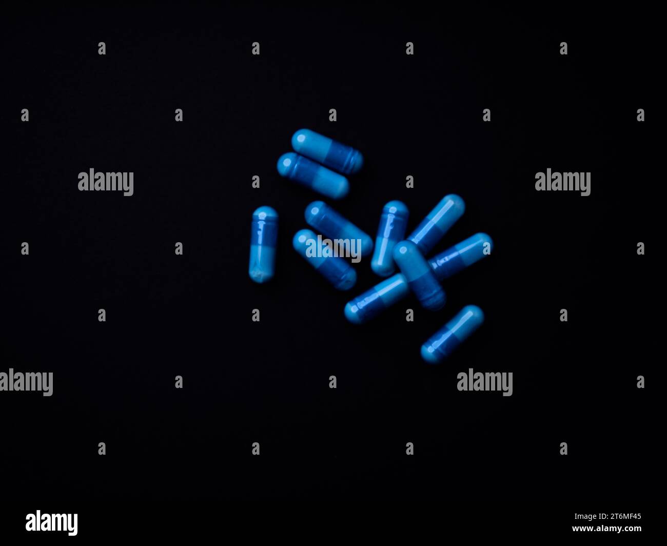 Capsule di aminoacidi su sfondo di carta scura. Messa a fuoco morbida. Primo piano. Copia spazio. Foto Stock