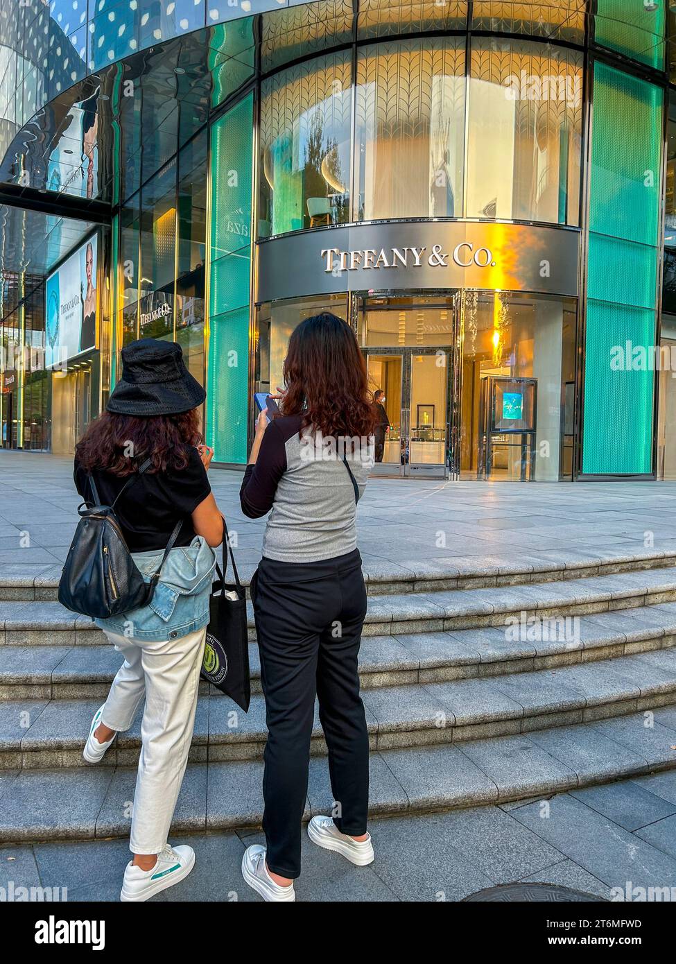 Shanghai, Cina, Street Scene, quartiere degli affari, due adolescenti cinesi da dietro, che guardano gli smartphone, Front of Tiffany & Co. Gioielleria, centro città, capitalismo cinese Foto Stock