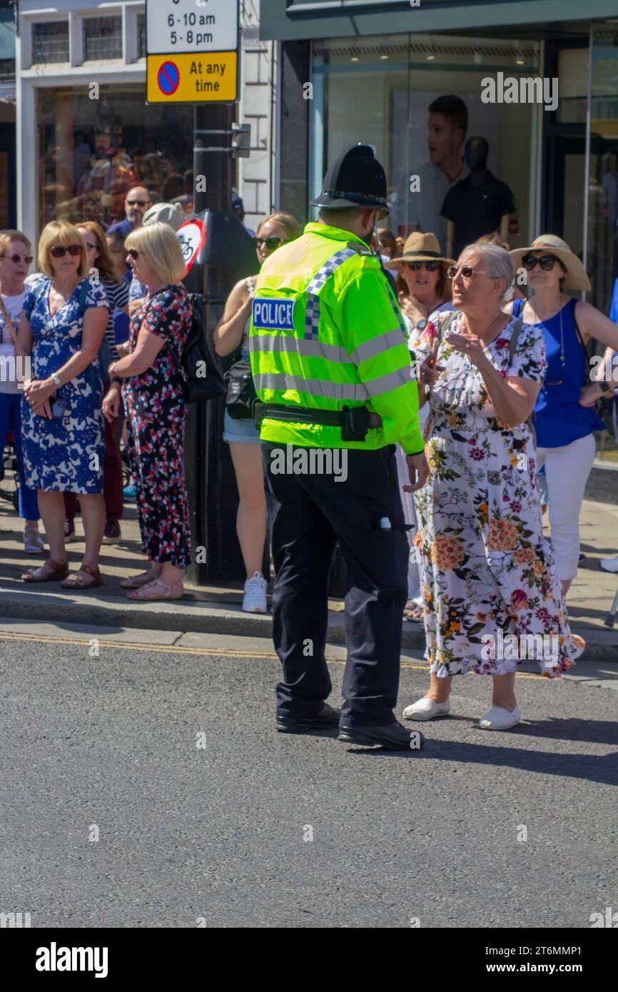 15 giugno 2023 Un agente di polizia in uniforme che dirige i turisti vicino al Castello di Windsor, una famosa residenza reale a Windsor Berkshi Foto Stock