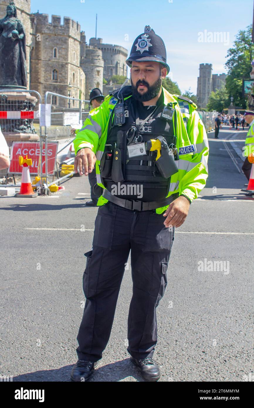 15 giugno 2023 Un agente di polizia in uniforme che dirige i turisti vicino al Castello di Windsor, una famosa residenza reale a Windsor Berkshi Foto Stock