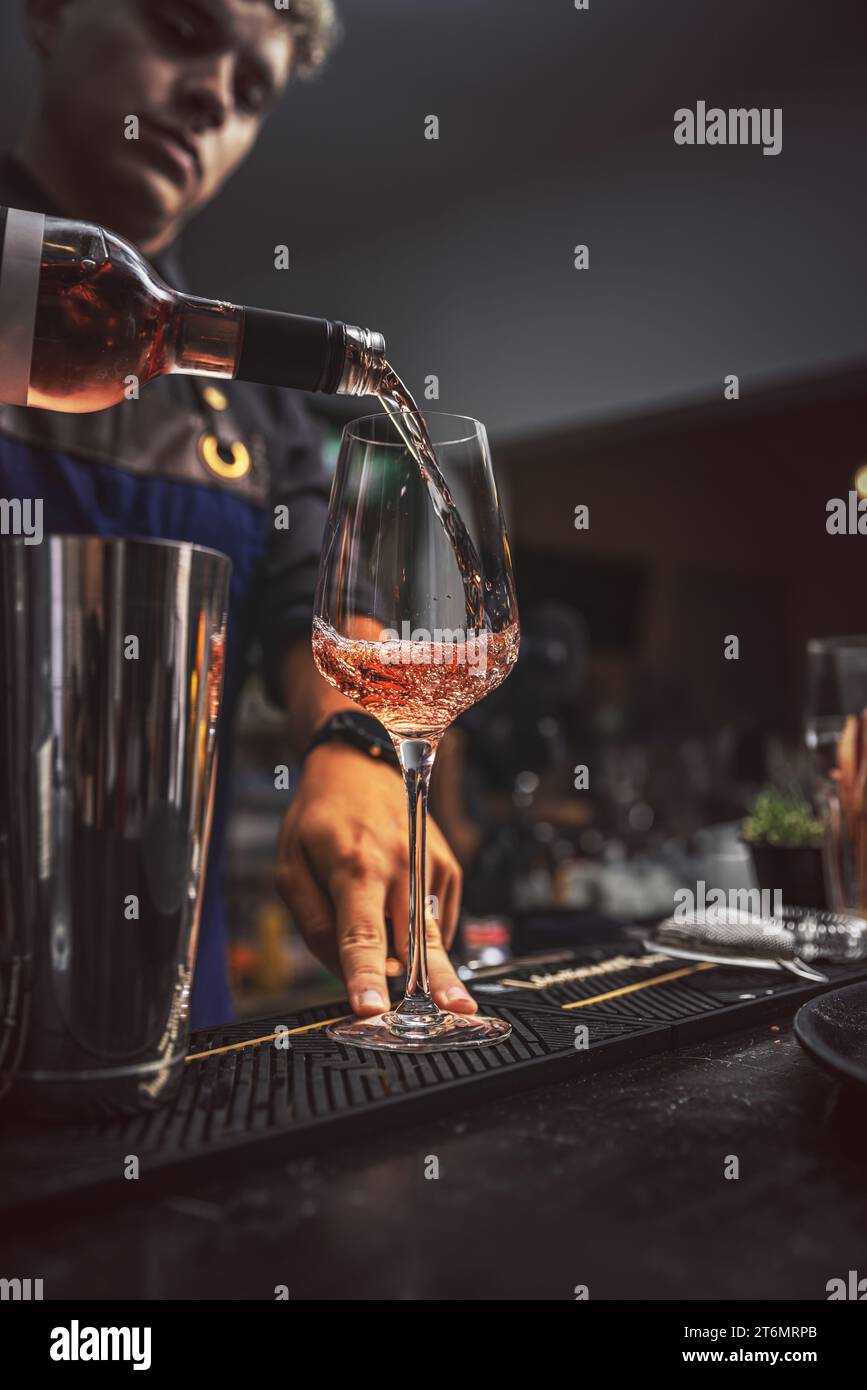 Barman al lavoro, versare il vino in un bicchiere di vino Foto Stock