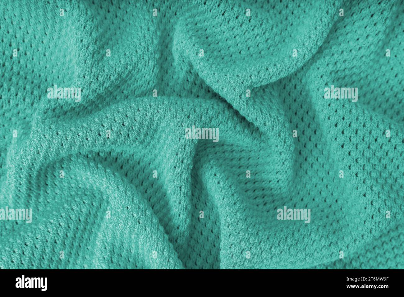 Tessuto in lana di lana increspata e increspata di colore turchese. Sfondo di tessuto lavorato a maglia con motivo a punti. Struttura tessile, superficie stoffa, weav Foto Stock