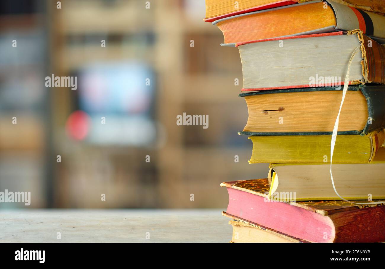 Pila di libri con sfondo sfocato, lettura, apprendimento, istruzione o concetto di ufficio domestico Foto Stock