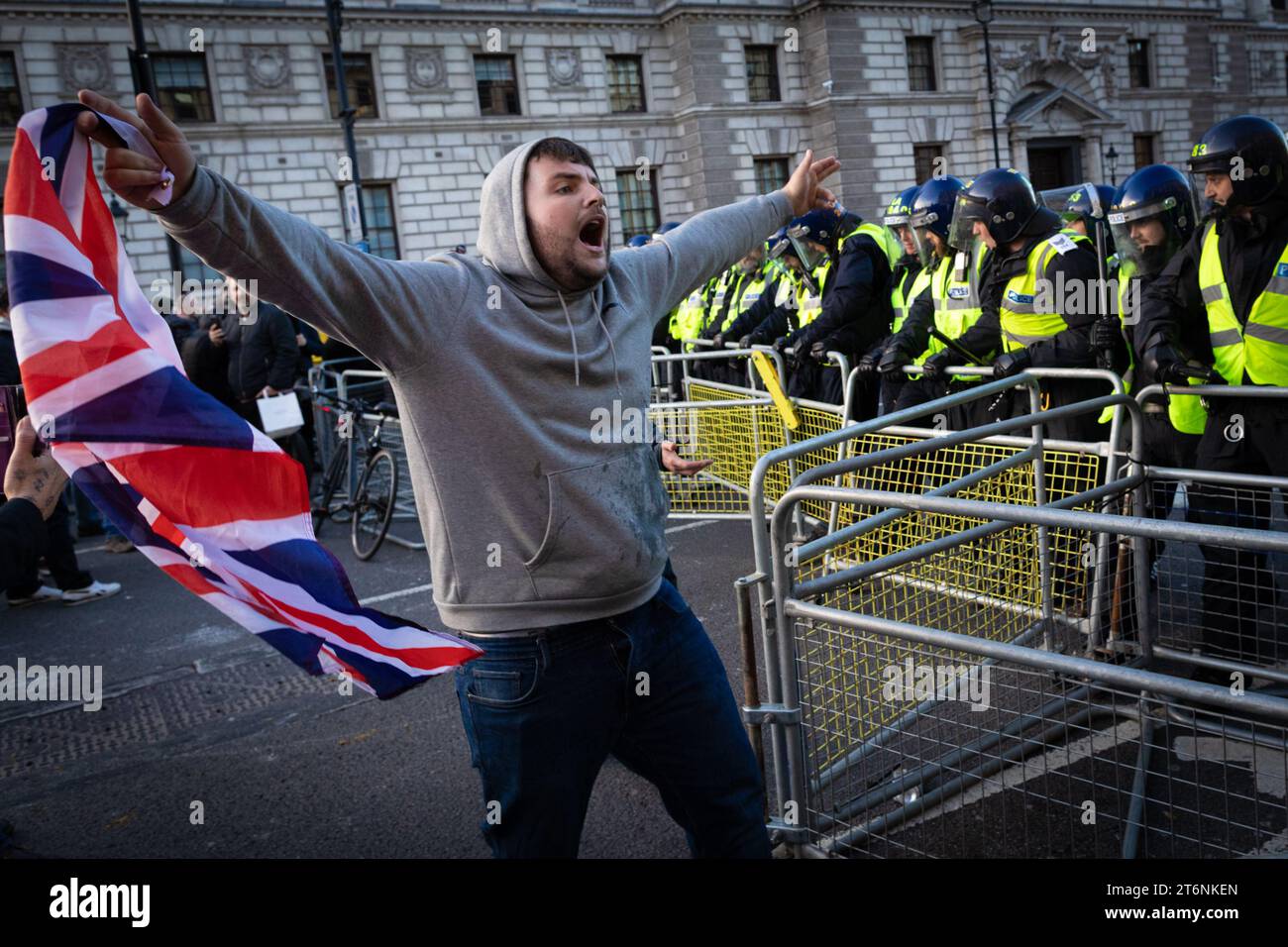 Londra, Regno Unito, 11 novembre 2023. Un uomo con una bandiera Union Jack si trova di fronte al cordone della polizia durante una chiamata per sorvegliare il cenotafio. Tommy Robinson ha espresso il motivo per scoraggiare qualsiasi manifestante pro-palestinese che potrebbe voler marciare attraverso Whitehall durante il weekend della memoria. Questo arriva dopo cinque settimane consecutive di proteste per fermare la guerra a Gaza.ÊAndy Barton / Alamy Live News Foto Stock