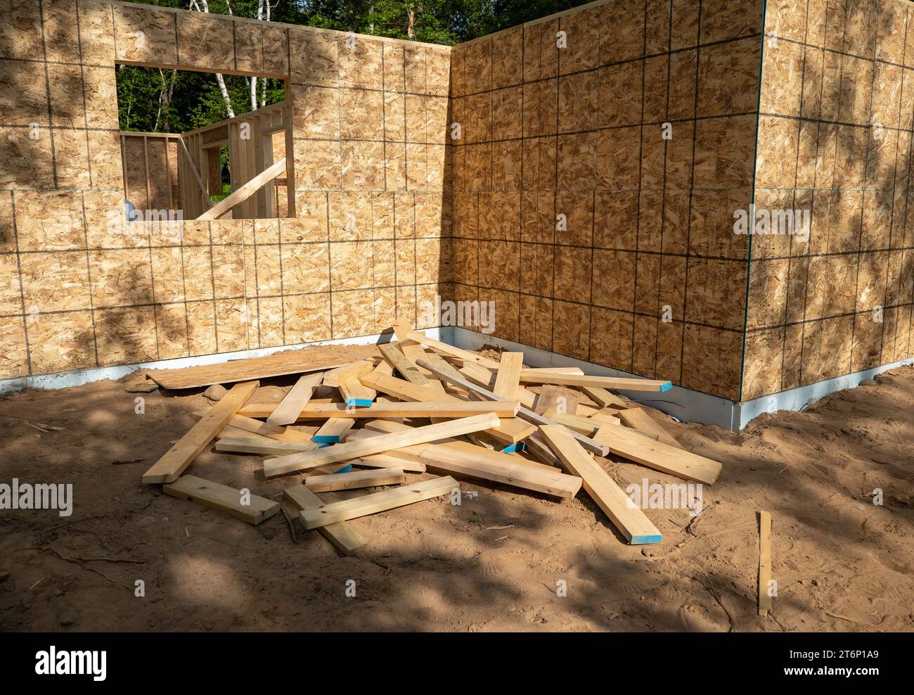 Un mucchio di residui di pannelli di legno tagliati, lasciati in un mucchio in un sito di costruzione. Foto Stock