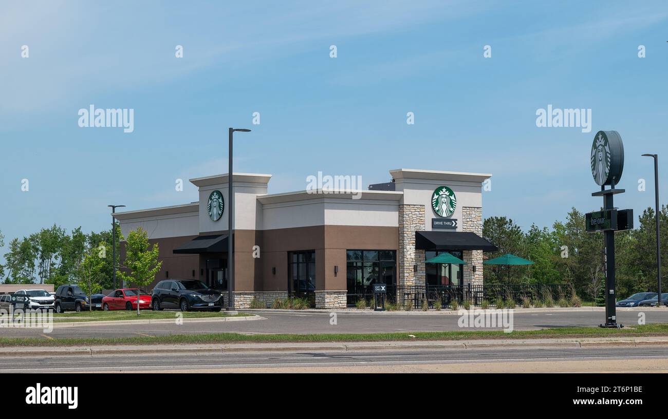 BEMIDJI, Minnesota - 3 giugno 2023: Edificio indipendente di caffetteria Starbucks in una giornata di sole, con auto allineate nella corsia di percorrenza. Foto Stock