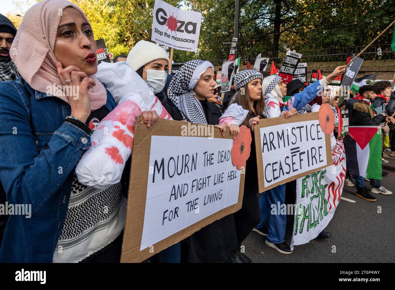 Le donne con cartelli "piangono i morti e combattono come l'inferno per i vivi” e "l'armistizio equivale a cessate il fuoco”. Protesta contro il bombardamento di Gaza. Londra. Foto Stock