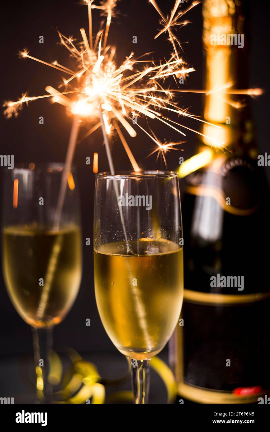 Bicchiere di champagne bruciato sparkler con sfondo scuro Foto Stock