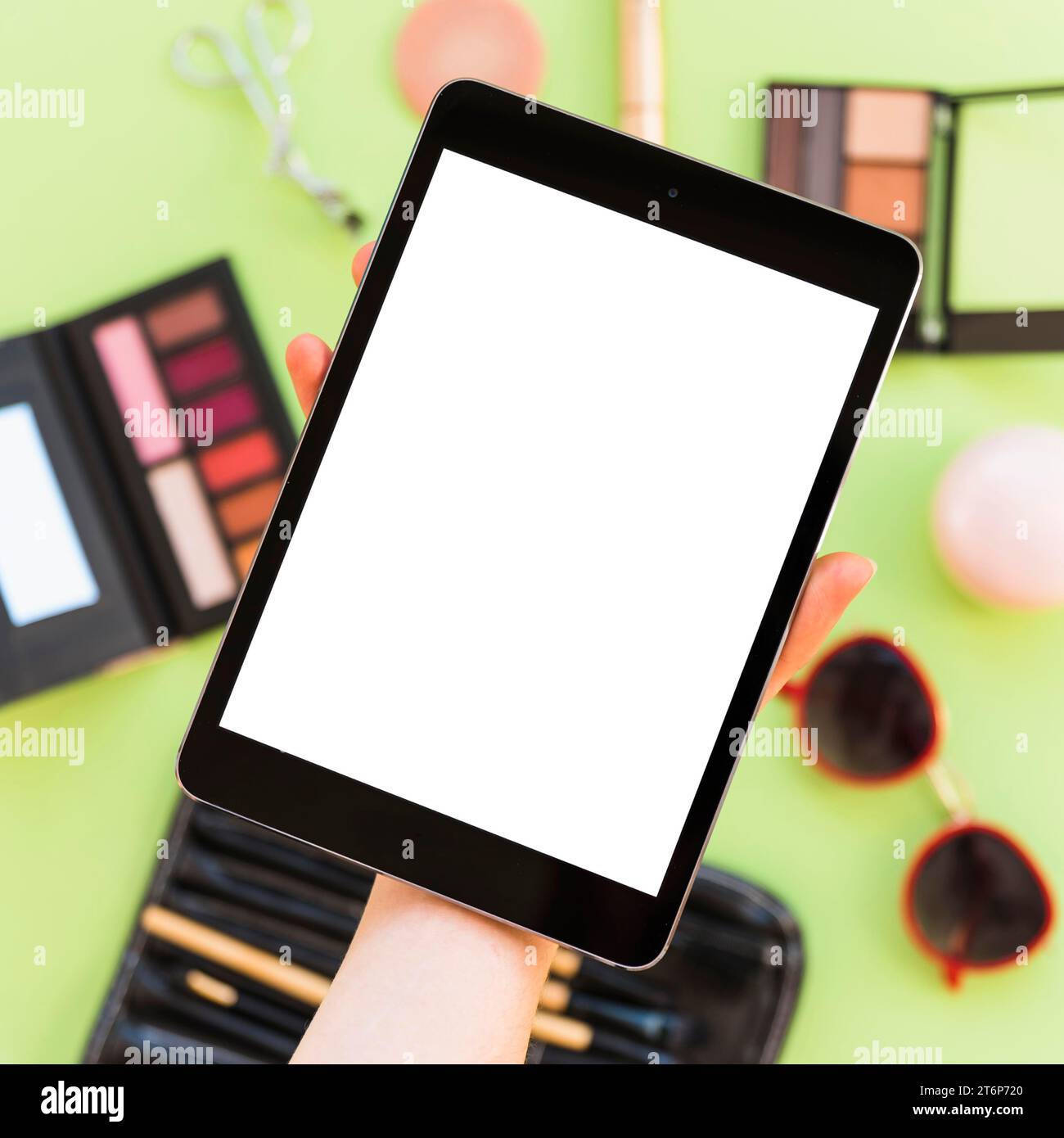 Primo piano della mano di una persona che mostra cosmetici vuoti sullo schermo di una tavoletta digitale Foto Stock
