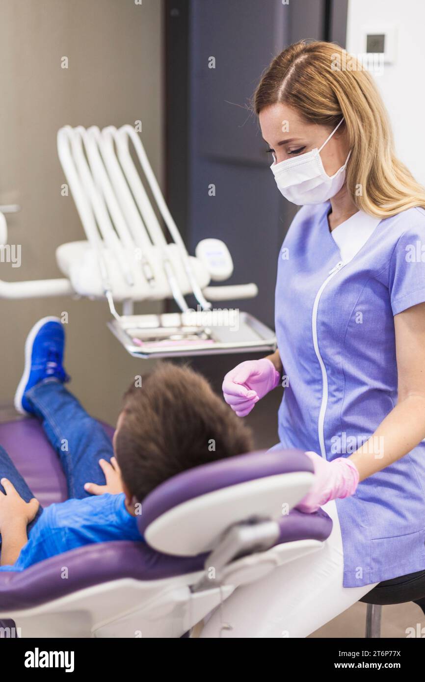 Paziente dentista che si appoggia a una sedia dentale Foto Stock
