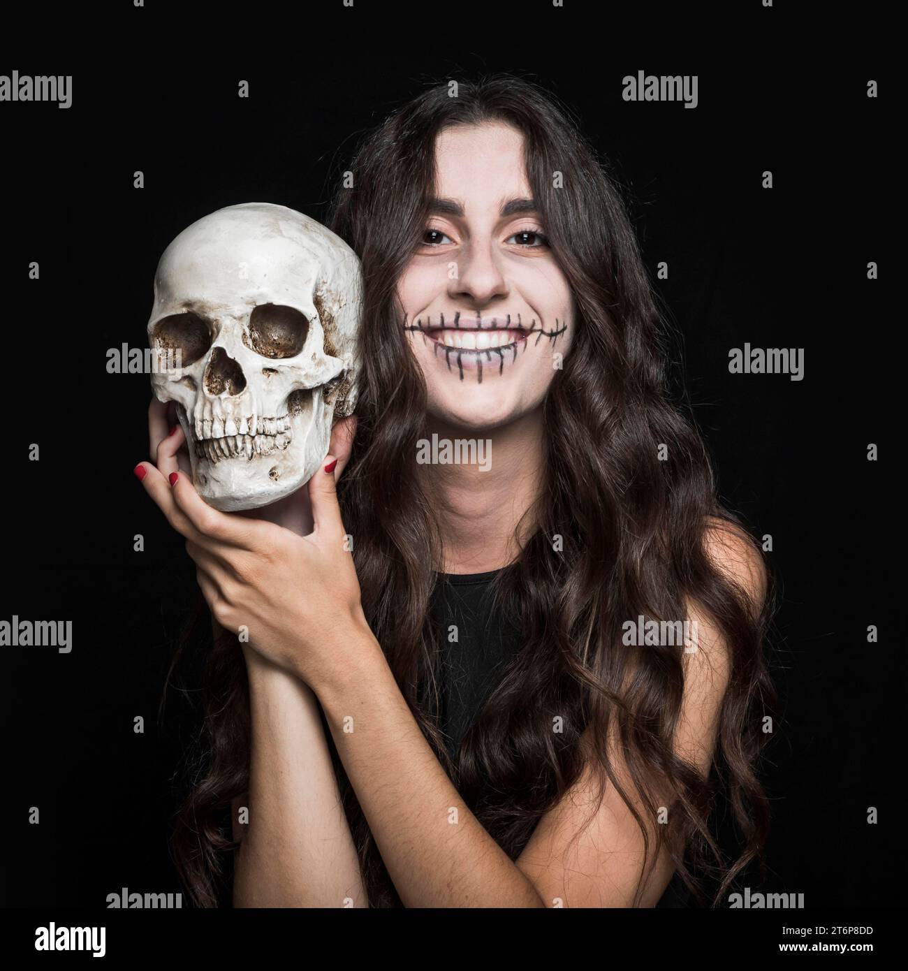 Donna ridendo che tiene il teschio Foto Stock