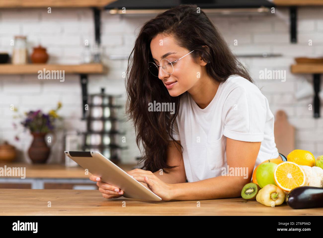 Donna bruna con vista laterale e tablet Foto Stock