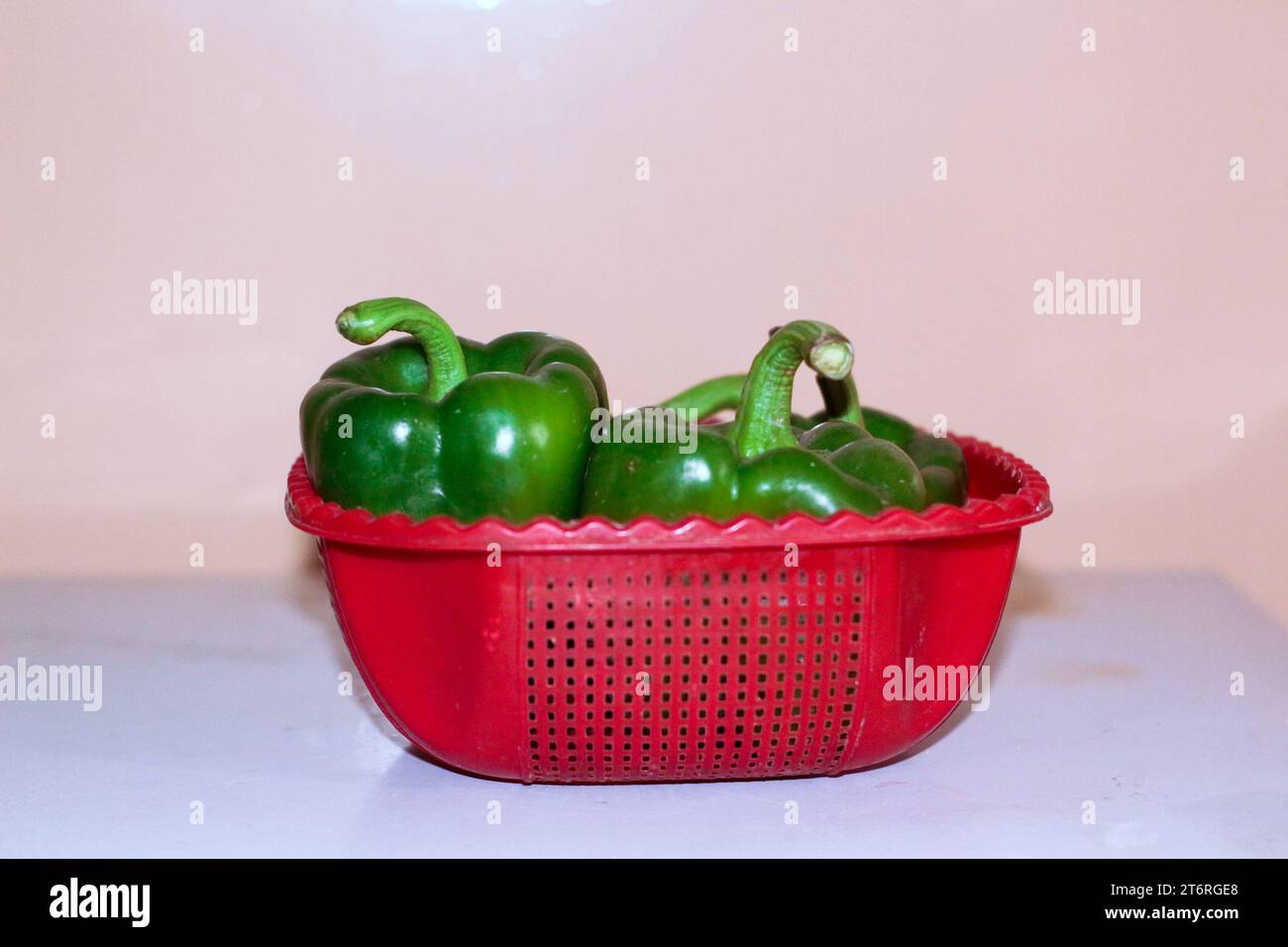 Cestello pieno di capsico verde con sfondo bianco Foto Stock