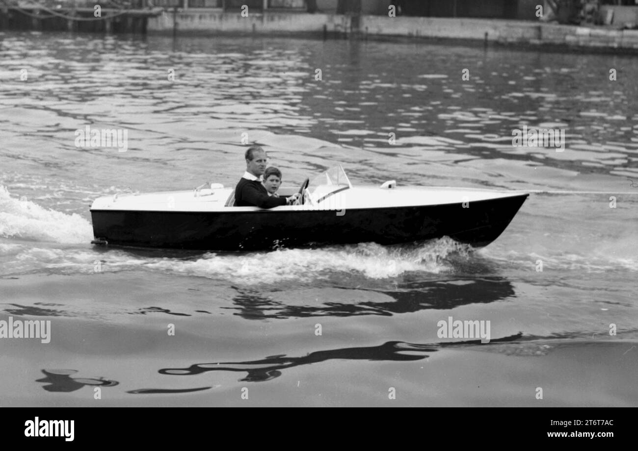 Foto datata 07/08/57 del principe Carlo con suo padre il duca di Edimburgo al volante, mentre fanno un giro in barca a motore sul fiume Medina a Cowes, Isola di Wight. Foto di ogni anno della vita del re sono state compilate dall'agenzia di stampa PA per celebrare il 75° compleanno di re Carlo III. Data di emissione: Domenica 12 novembre 2023. Foto Stock