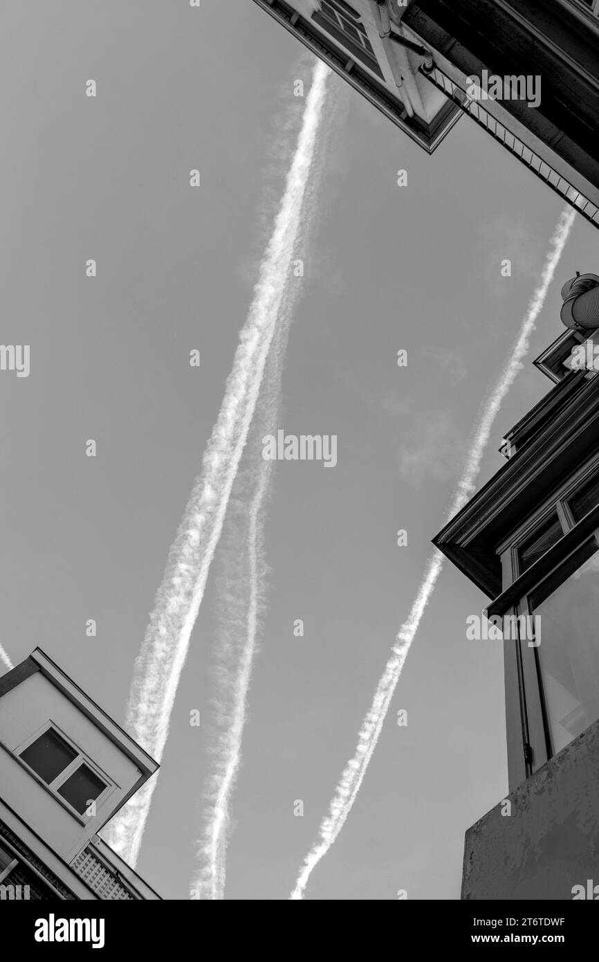 Fotografia in bianco e nero di Sky and Houses with Roofs and Traces from Jets or Plane, Netherland, the Hague. Foto Stock
