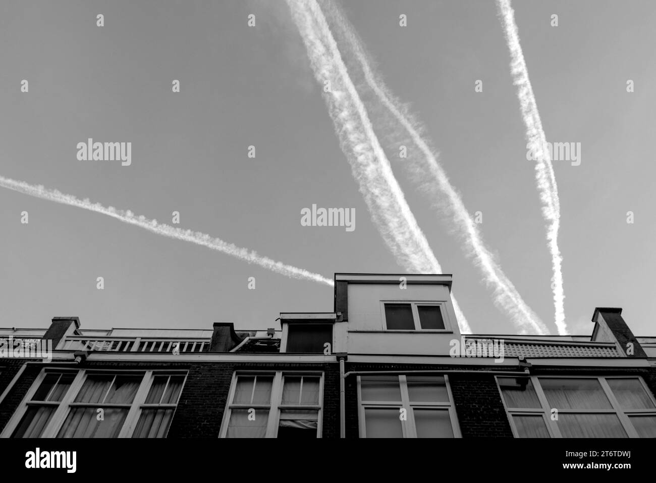 Fotografia in bianco e nero di Sky and Houses with Roofs and Traces from Jets or Plane, Netherland, the Hague. Foto Stock