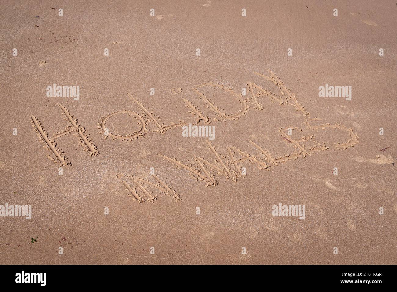 Vacanza in Galles scritta sulla sabbia su una spiaggia nel Galles del Nord nel Galles del Regno Unito Foto Stock