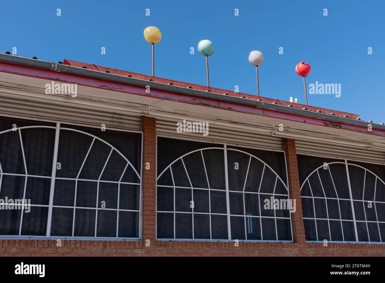 Finestre con inserti a scomparsa ad arco con riquadri, quattro palline colorate decorative, architettura googie del MidCentury, Route 66, Santa Rosa, New Mexico, USA. Foto Stock