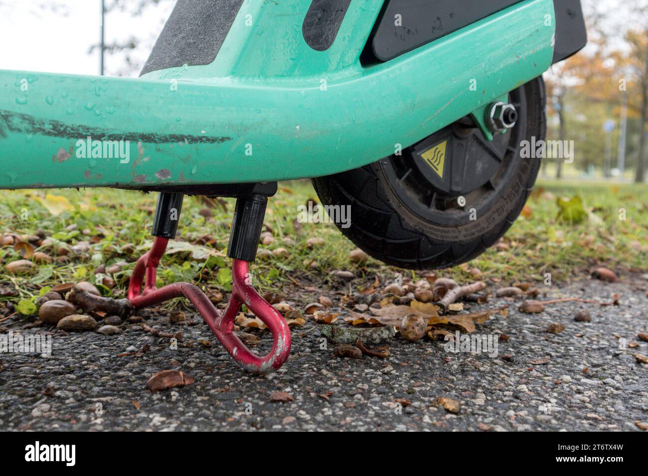 Uno scooter-bicicletta verde posizionato sulla gamba in posizione di arresto Foto Stock