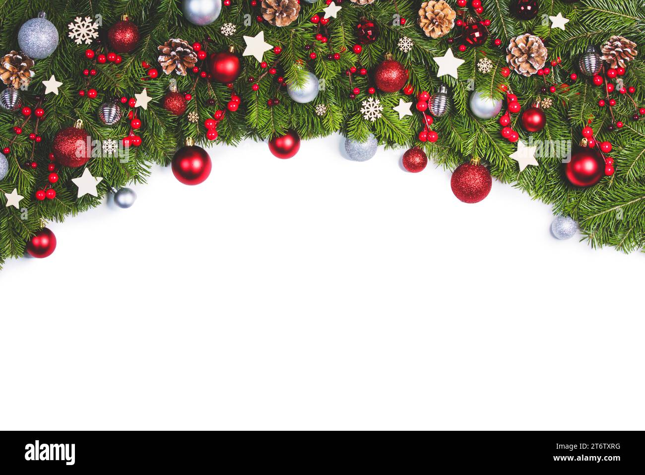 Cornice del bordo natalizio di rami d'albero su sfondo bianco con spazio copia isolato, decorazioni rosse e argentate di palle e ghirlanda Foto Stock