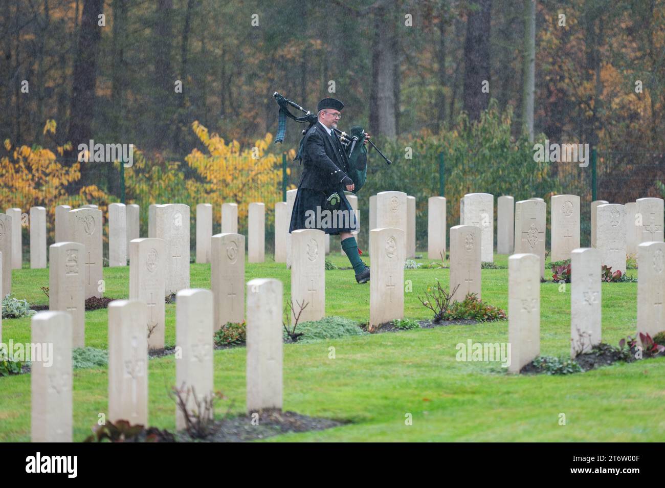 12 novembre 2023, Brandeburgo, Stahnsdorf: Un bagpiper gioca tra le tombe di guerra in un servizio domenicale della memoria per britannici e tedeschi al cimitero militare britannico. Al servizio commemorativo presso il Südwestkirchhof Stahnsdorf, britannici e tedeschi onorano congiuntamente i soldati che morirono nelle due guerre mondiali. Oltre 4.000 vittime di guerra e tirannia sono sepolte nel cimitero. Foto: Christophe Gateau/dpa Foto Stock