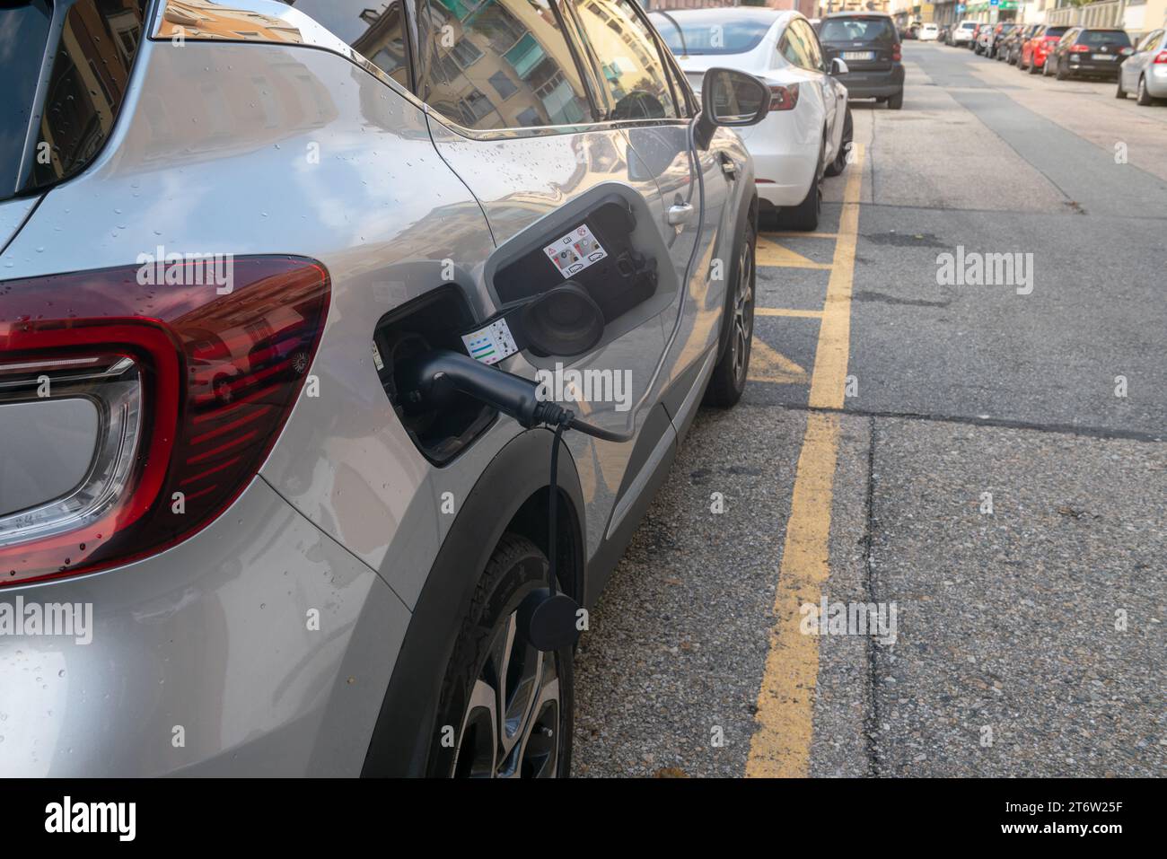 ricarica per auto elettriche, collegalo per assorbire energia nel parcheggio dedicato. Zero emissioni nelle città con politiche ecologiche verdi. bonus Foto Stock