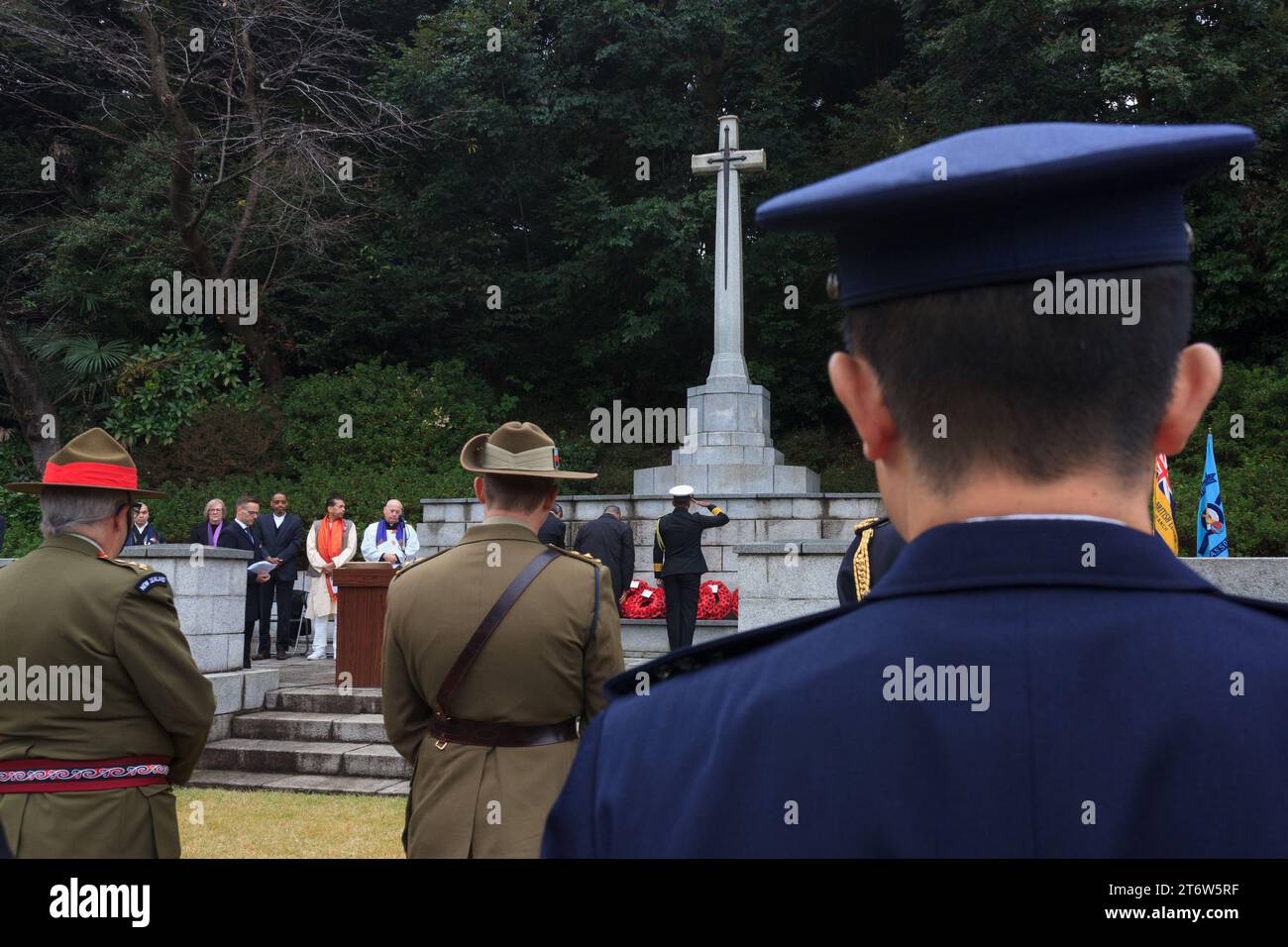 Il personale militare saluta la Croce del sacrificio durante le cerimonie della domenica della memoria presso il cimitero delle Graves di guerra del Commonwealth di Hodagaya a Yokohama. Quest'anno l'ambasciata neozelandese ha ospitato questo evento commemorativo che segna la fine della prima guerra mondiale e onora tutti coloro che sono morti in servizio militare. Foto Stock