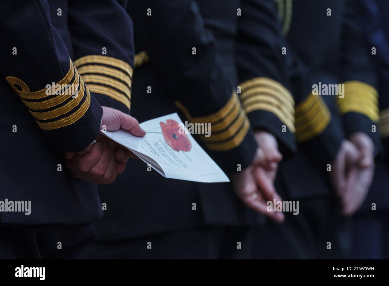 Gli uomini in uniforme militare tengono un programma per le cerimonie della domenica della memoria al cimitero di Hodagaya Commonwealth War Graves a Yokohama. Quest'anno l'ambasciata neozelandese ha ospitato questo evento commemorativo che segna la fine della prima guerra mondiale e onora tutti coloro che sono morti in servizio militare. Foto Stock