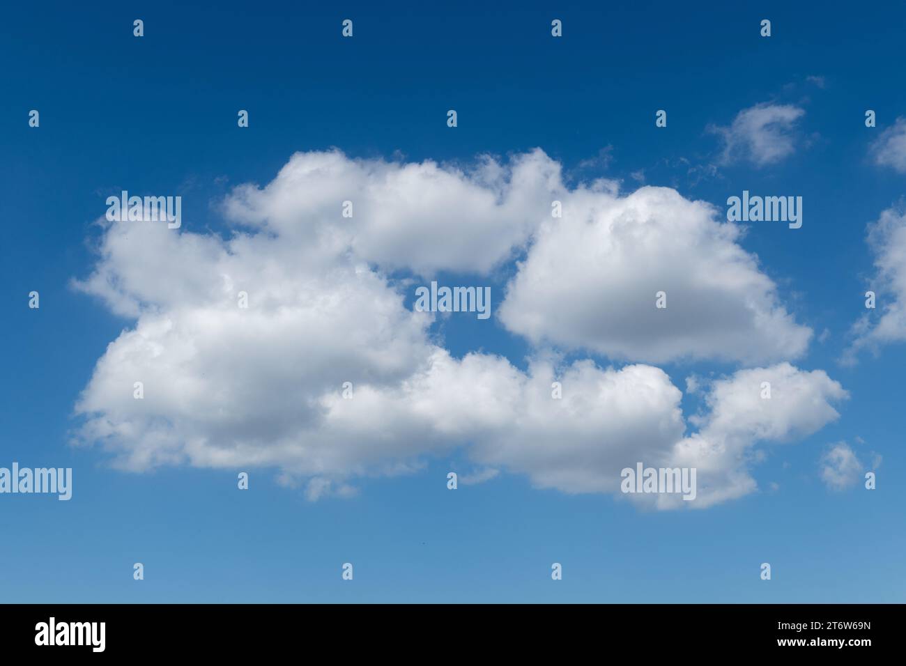 Dettaglio di una formazione di nuvole cumulus bianca, piumino, in cotone, sullo sfondo di un cielo azzurro e luminoso durante le giornate più belle. Foto Stock