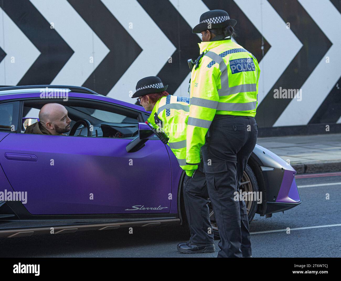 Gli agenti della polizia metropolitana controllano i documenti di un autista di super auto, Londra, Regno Unito. Foto Stock