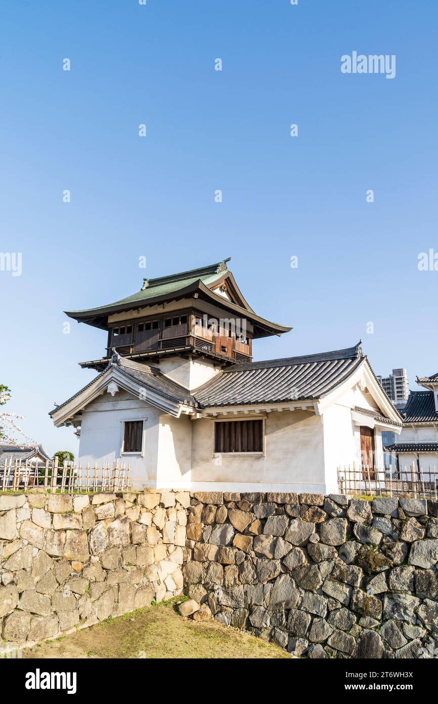 L'originale Shorou, torretta con campana, un importante patrimonio culturale, su una base di pietra ishigaki, alla luce del sole al castello di Fukuyama, in Giappone. Cielo azzurro. Foto Stock